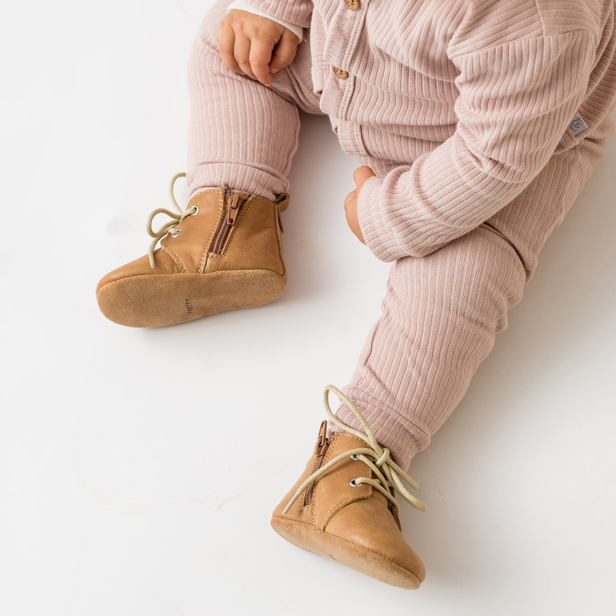Toddler wearing Tan boots with white laces