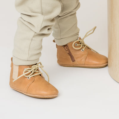 Toddler wearing Pair of Tan boots with white laces