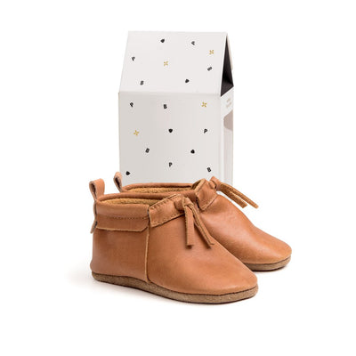 Pair of toddler boots in natural colour next to box
